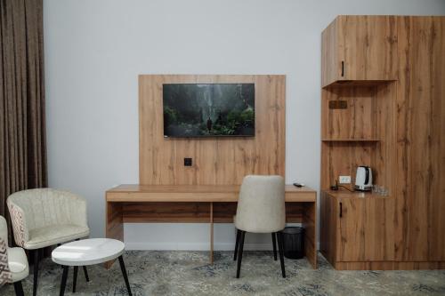 a room with a desk with two chairs and a television at Kampoeng Indonesia Hotel in Khodzha-Ismail