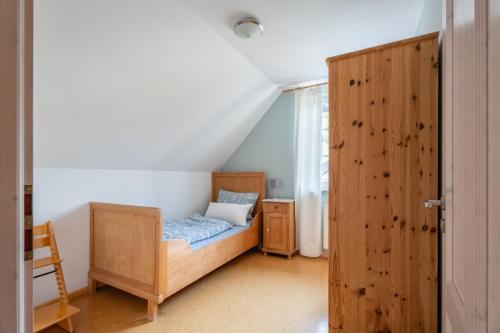 a bedroom with a bed and a wooden door at Ferienwohnung im Obergeschoss in Durbach