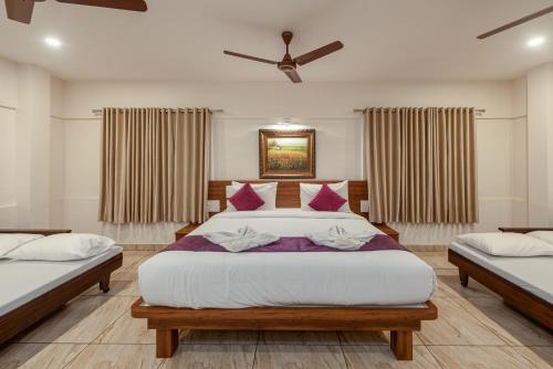 a bedroom with two beds and a ceiling fan at Shoolin Resorts in Manipal