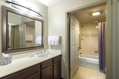 a bathroom with a sink and a mirror and a tub at Residence Inn by Marriott Boston Franklin in Franklin