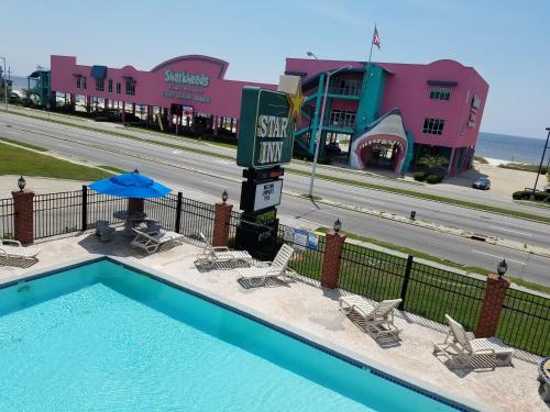 a swimming pool at a resort with a hotel at Star Inn Biloxi in Biloxi