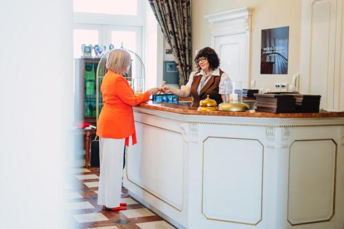 a woman standing at a counter in a kitchen at Dwór Prezydencki Boutique Hotel & SPA in Tarnów