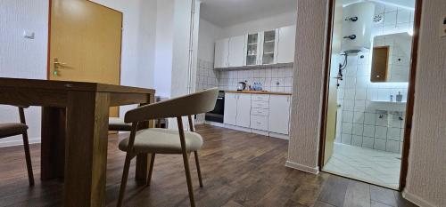 a kitchen with a table and chairs and a shower at Apartments AS Dubrave in Dubrave Gornje