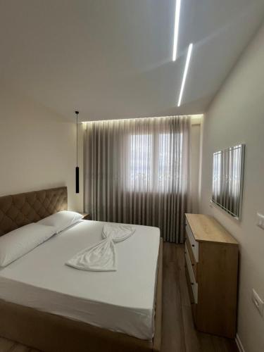 a bedroom with a large bed and a window at Golden Stay in Pogradec