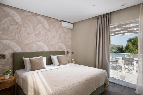 a bedroom with a large bed and a balcony at Athenian Riviera Hotel& Suites in Athens