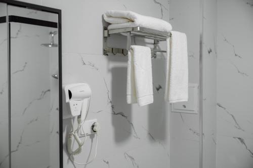 a bathroom with white towels and a phone at Kampoeng Indonesia Hotel in Khodzha-Ismail