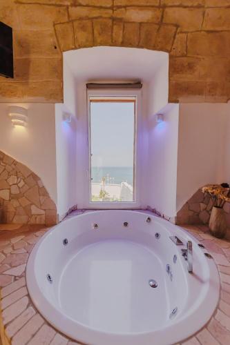 a large white tub in a room with a window at Ventidue Venti in Bari