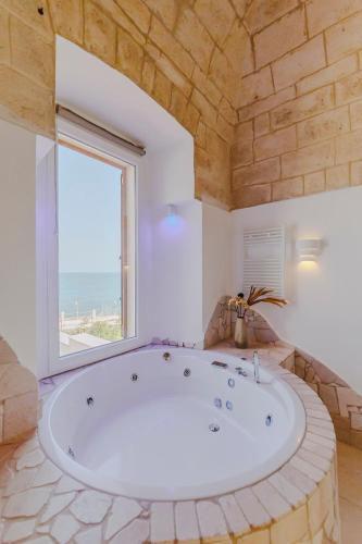 a large bath tub in a room with a large window at Ventidue Venti in Bari
