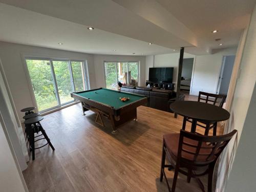 a living room with a pool table and a kitchen at Pool Table Private Beach - Breakfast Included - Fontainebleau in Labelle