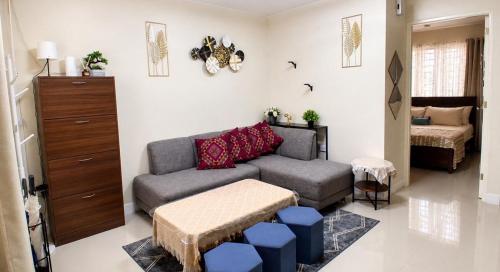 a living room with a couch and a bedroom at J&J Antipolo Place 2BR with Netflix & Karaoke in Antipolo