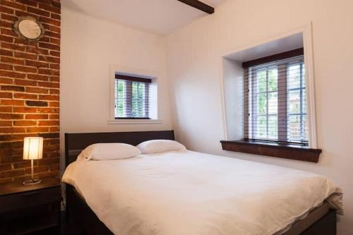 a bedroom with a large bed with two windows at Comfort & Getaway in Old Levis - Studio Urbain in Lévis