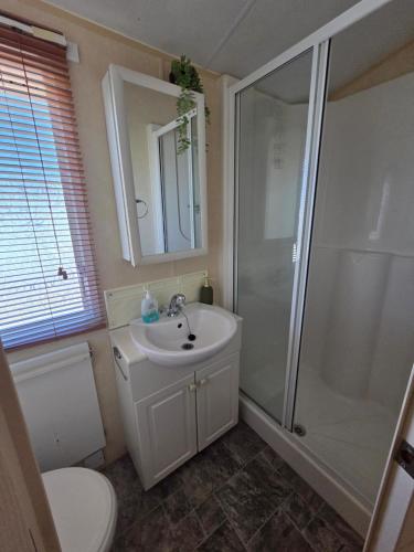 a bathroom with a sink and a shower and a toilet at Kingfisher Oak.1044 in Ingoldmells