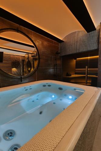 a jacuzzi tub in a room with a mirror at Hotel Awam in Hradec Králové