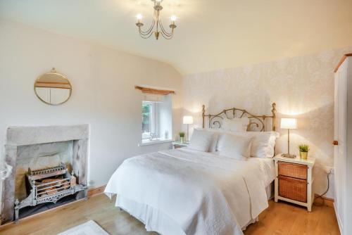 a bedroom with a white bed and a fireplace at 1 Bed in Starkholmes oc-q30994 in Matlock Bank