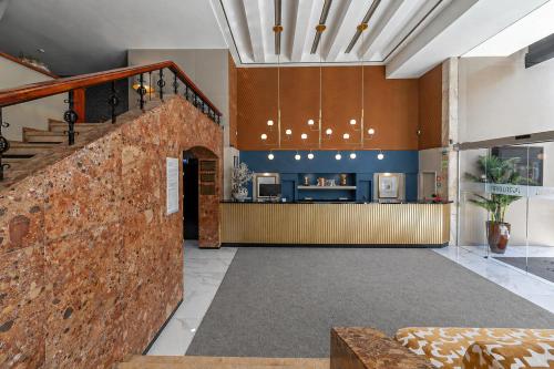 a lobby with a brick wall and a counter at Hotel Porto Mar in Matosinhos