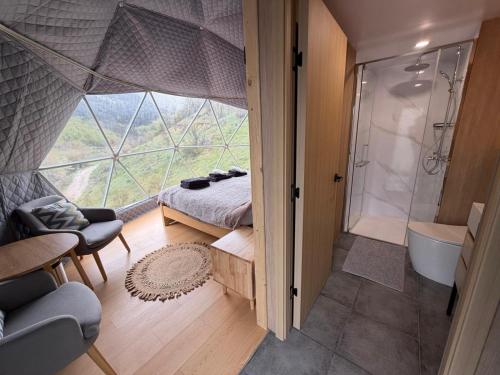 a room with a shower and a bed and a tub at Ursa Camp Mountain Glamping in Gornje Lipovo