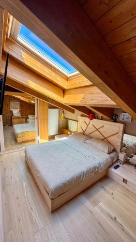 a large bed in a room with a wooden ceiling at Duplex Esclusivo Bardonecchia - Centro - Garage in Bardonecchia