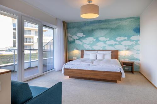 a bedroom with a bed and a painting of clouds at THE GRAND Ahrenshoop in Ahrenshoop