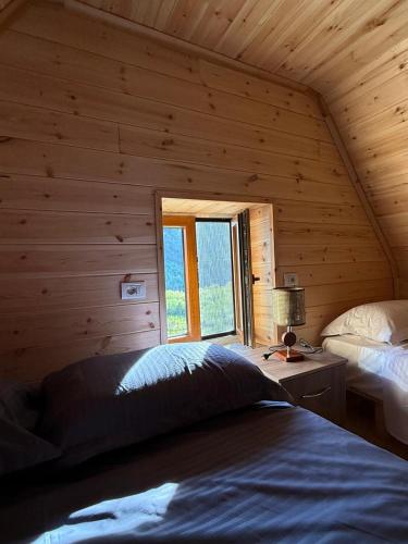a bedroom with a bed and a window in a log cabin at Oda Pisha Theth in Grumas