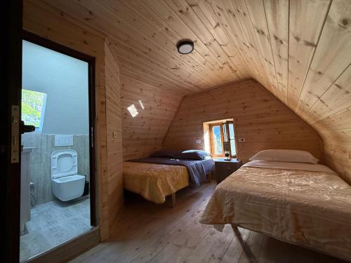 a bedroom with two beds in a wooden room at Oda Pisha Theth in Grumas