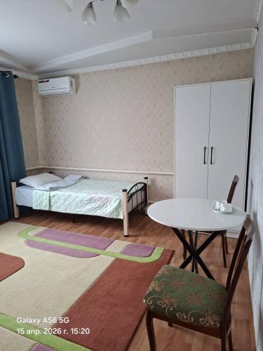 a small room with a bed and a table at Homestay JAISEL in Bishkek