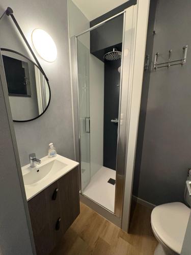 a bathroom with a sink and a shower with a mirror at Allium, Appt entièrement rénové avec parking in Courseulles-sur-Mer