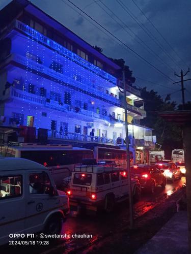 a large building with blue lights on it at night at Hotel Priyanshu in Madheso