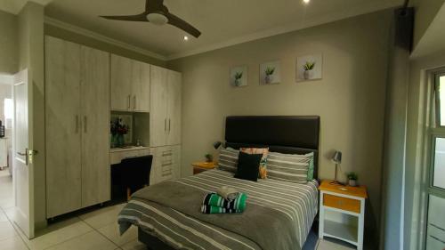 a bedroom with a bed and a ceiling fan at Utopia Guest House in Alberton