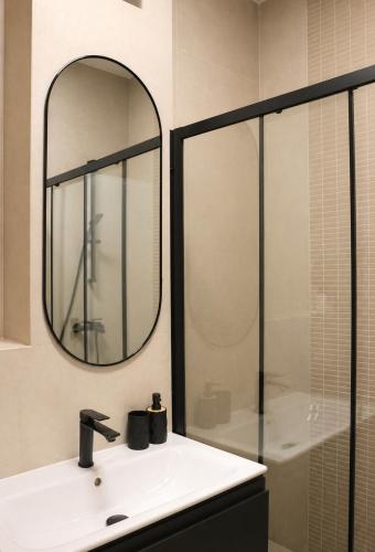 a bathroom with a sink and a mirror at Simba Apartments Baile Felix in Baile Felix