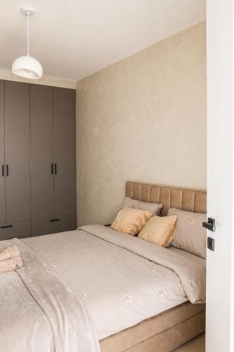 a bedroom with a large bed with white sheets at Simba Apartments Baile Felix in Baile Felix