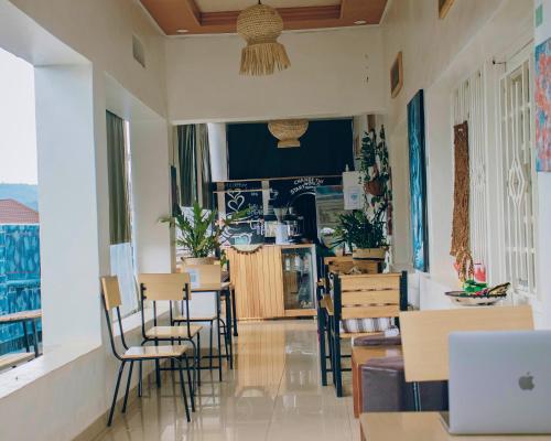 a restaurant with chairs and a laptop on a table at Kalpho Art Center Guesthouse- near Embassy District in Kigali