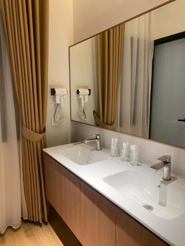 a bathroom with a sink and a large mirror at Blissful Homestay Batam in Nagoya
