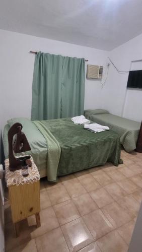 a bedroom with a green bed and a table at Ciza - Departamento Temporario en Paraná in Paraná