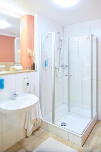 a bathroom with a shower and a sink at Altstadthotel Arte in Fulda