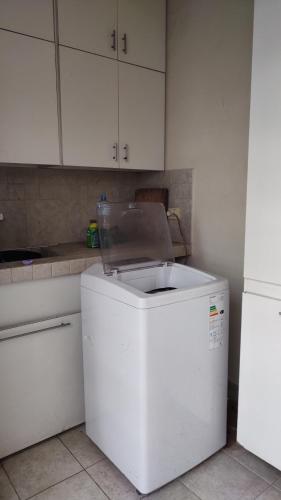 a white refrigerator in a kitchen with white cabinets at Casa 51 La Plata in La Plata