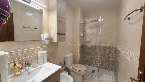 a bathroom with a shower and a toilet and a sink at Estudios Costavigía Mazagón by Ramona in Mazagón