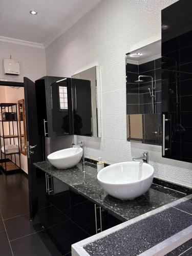 a bathroom with two sinks and two mirrors at Les Villas du Douar in Azib Oulad Lâdem