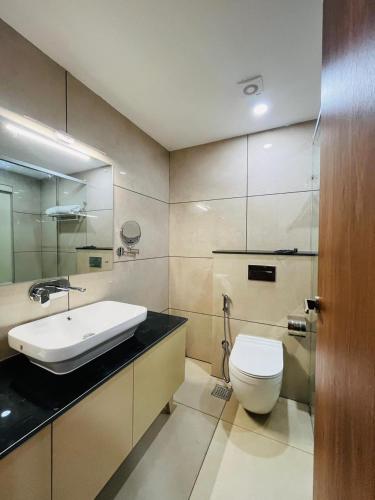 a bathroom with a white toilet and a sink at Celestial International in Taliparamba