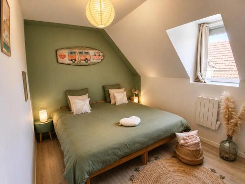 a bedroom with a green bed in a attic at Côte d'Opale - Maison Cocooning Classé 3 Étoiles in Marquise