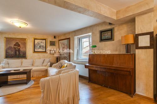 a living room with a couch and a piano at Budva Old Town 3 bedroom Condo in Budva