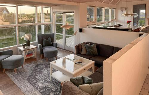 a living room with a couch and chairs and windows at Lovely Home In Saltum in Saltum