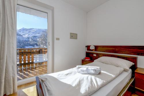 a bedroom with a bed and a large window at Albergo Panorama in Panchià