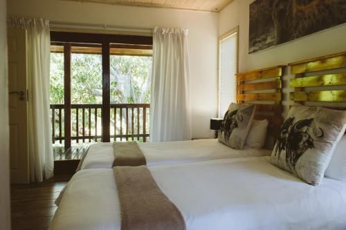 a bedroom with a large bed and a balcony at Monzi Safari Lodge in Monzi