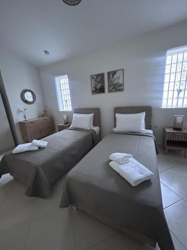 two beds sitting in a room with windows at House on the Hill in Anavyssos