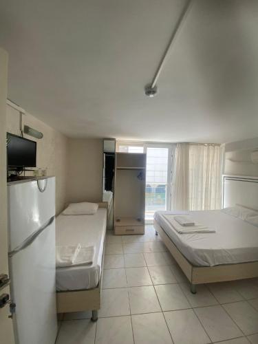 a hotel room with two beds and a refrigerator at Karsu apart otel in Erdemli