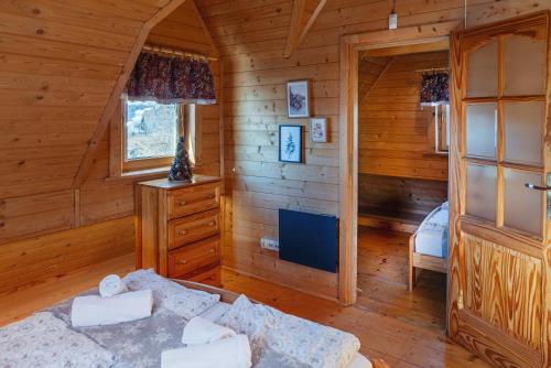 a room with a bed in a log cabin at Góralski Dom - Osada Gawlaki in Zakopane