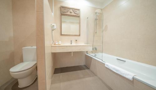 a bathroom with a toilet and a sink and a tub at Hotel Villa Marcilla by Pandora Hoteles in Marcilla