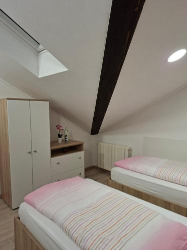 a attic bedroom with two beds and a dresser at Guest house Lavanda 4 in Njivice