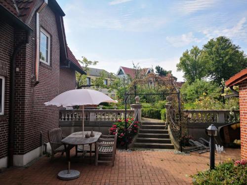 a table with an umbrella on a brick patio at Haus Thulboden in Heiligenhafen