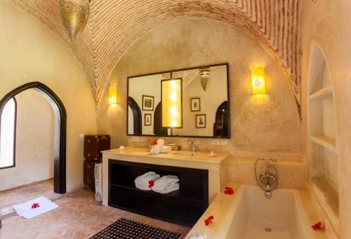 a bathroom with a tub and a sink and a mirror at PL Place Boutique Hôtel & Restaurant in Marrakesh